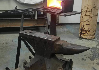 Anvil with steel heating in the forge in the background