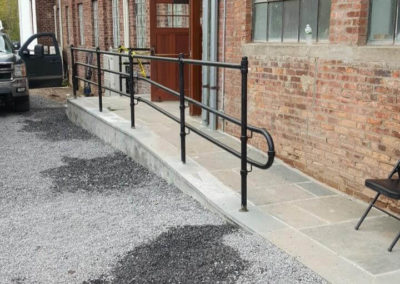 Black pipe railing against a brick building