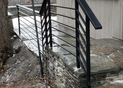 Horizontal railing mounted to a stone patio