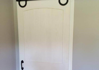 Black U shaped bard door hardware on a white door