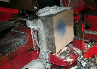 Large block of aluminum being cut in a band saw